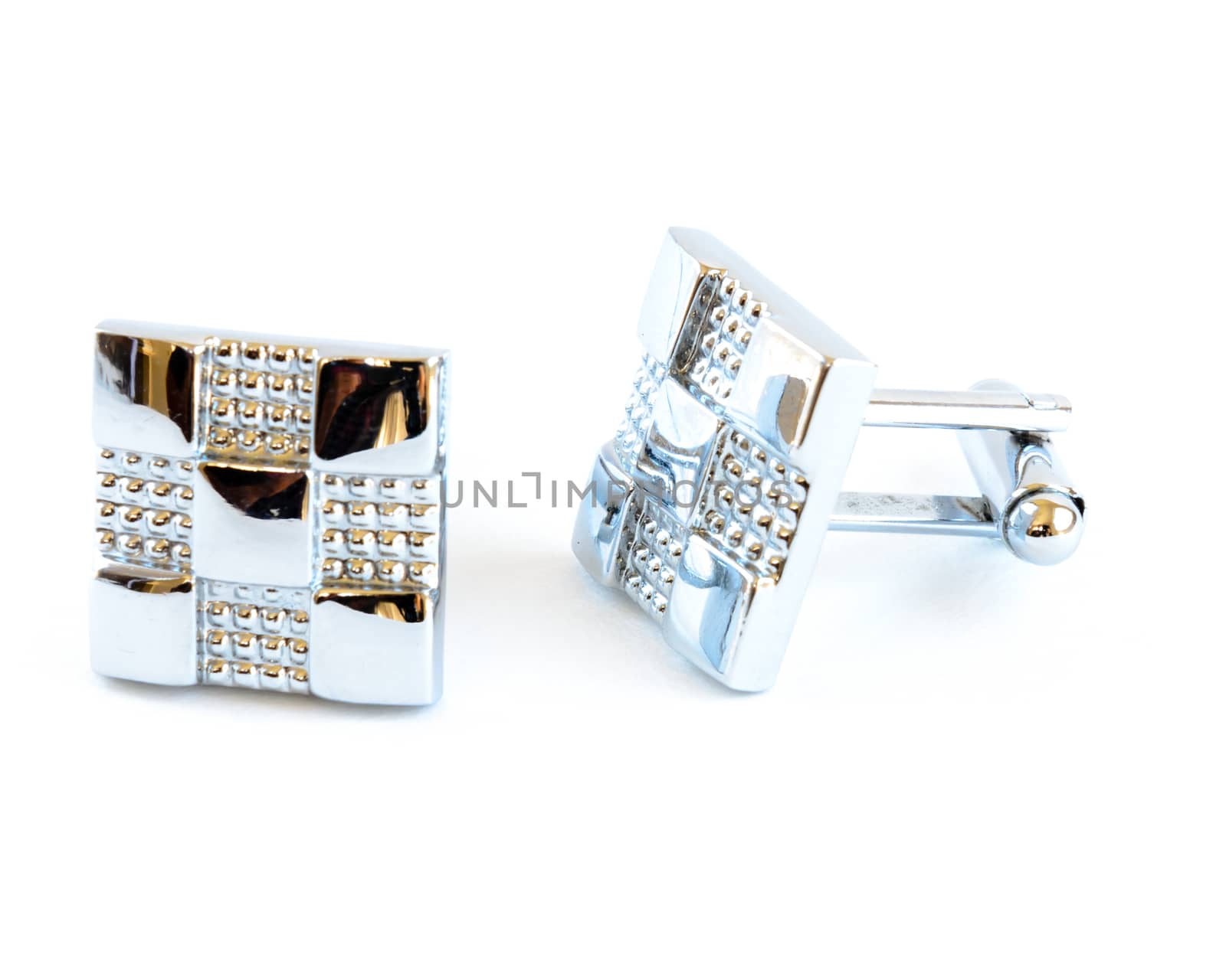 Close-up single pair of modern stainless steel cufflinks isolated on white background. Lifestyle trendy clothing accessories dress with clipping path and copy space.