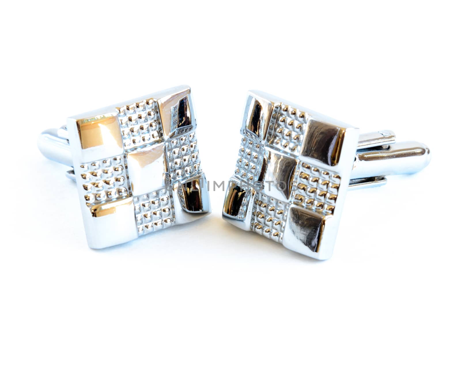 Close-up single pair of modern stainless steel cufflinks isolated on white background. Lifestyle trendy clothing accessories dress with clipping path and copy space.