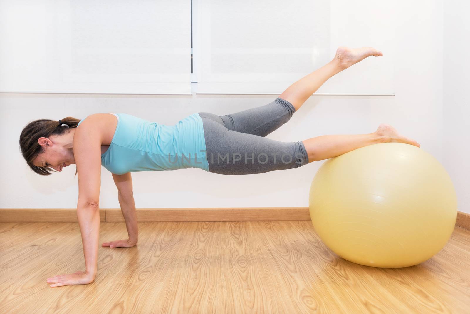Fitness woman in gym on pilates ball. Young woman doing exercise on fitness ball. by HERRAEZ