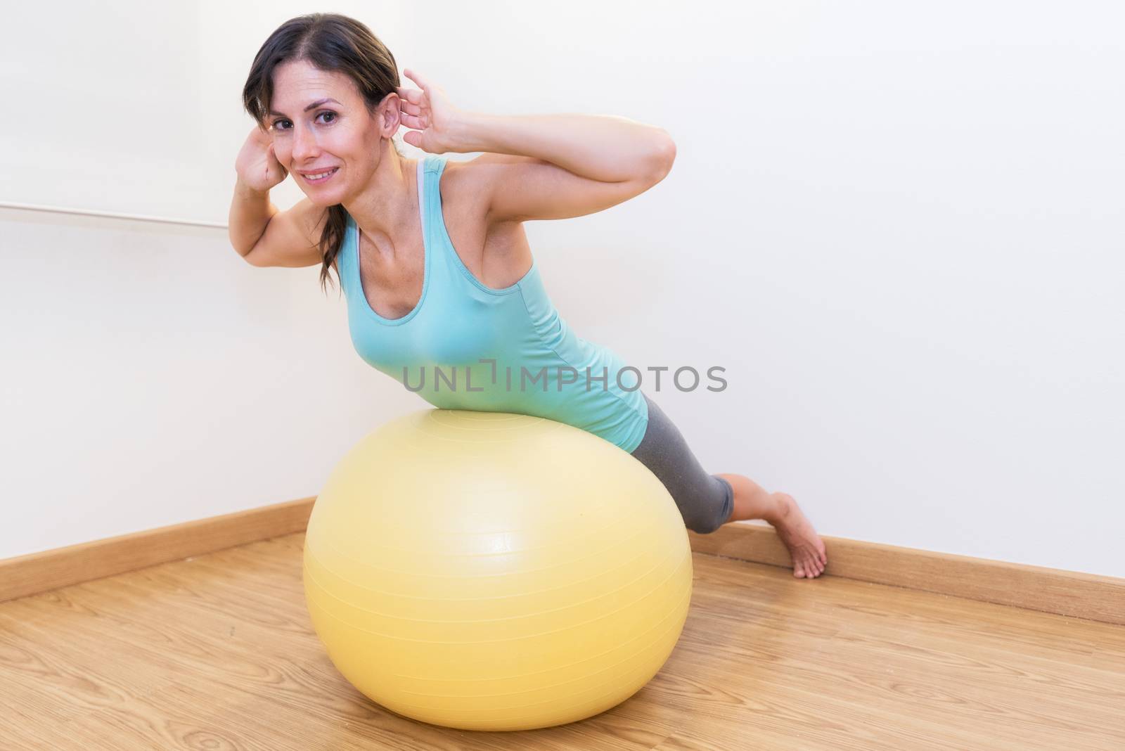 Fitness woman in gym on pilates ball. Young woman doing exercise on fitness ball.