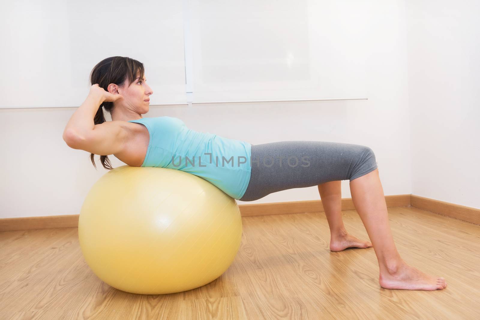 Fitness woman in gym on pilates ball. Young woman doing exercise on fitness ball.
