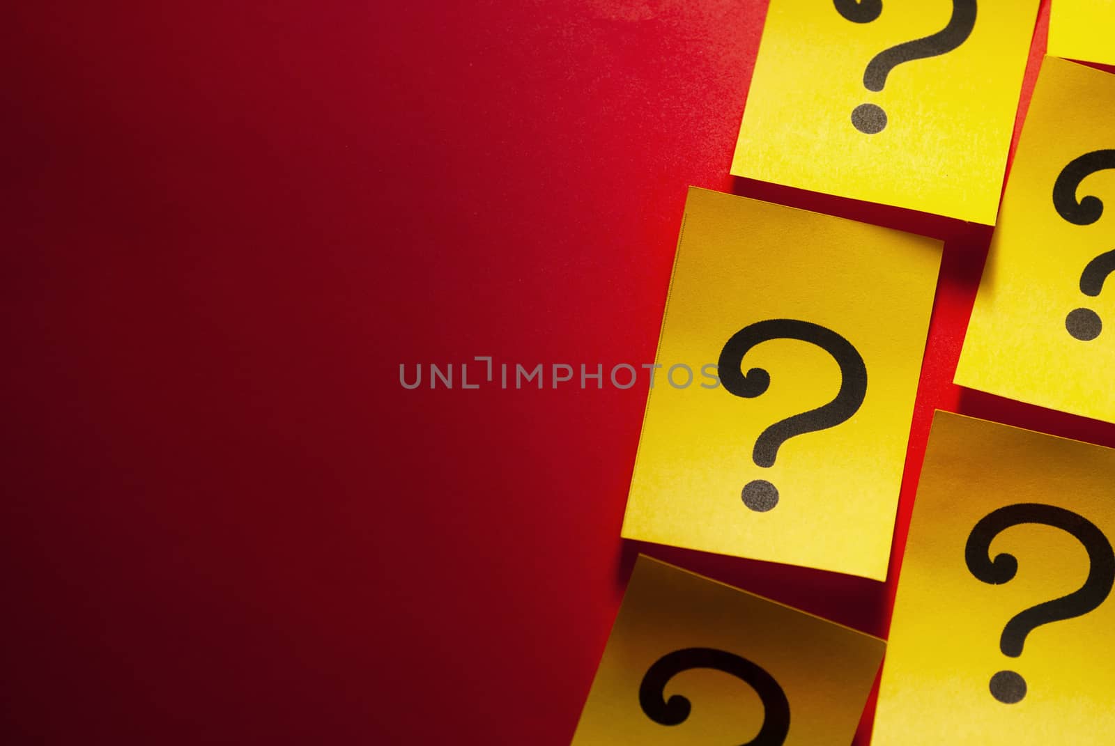 Side border of yellow cards with question marks arranged in rows on a red background with copy space