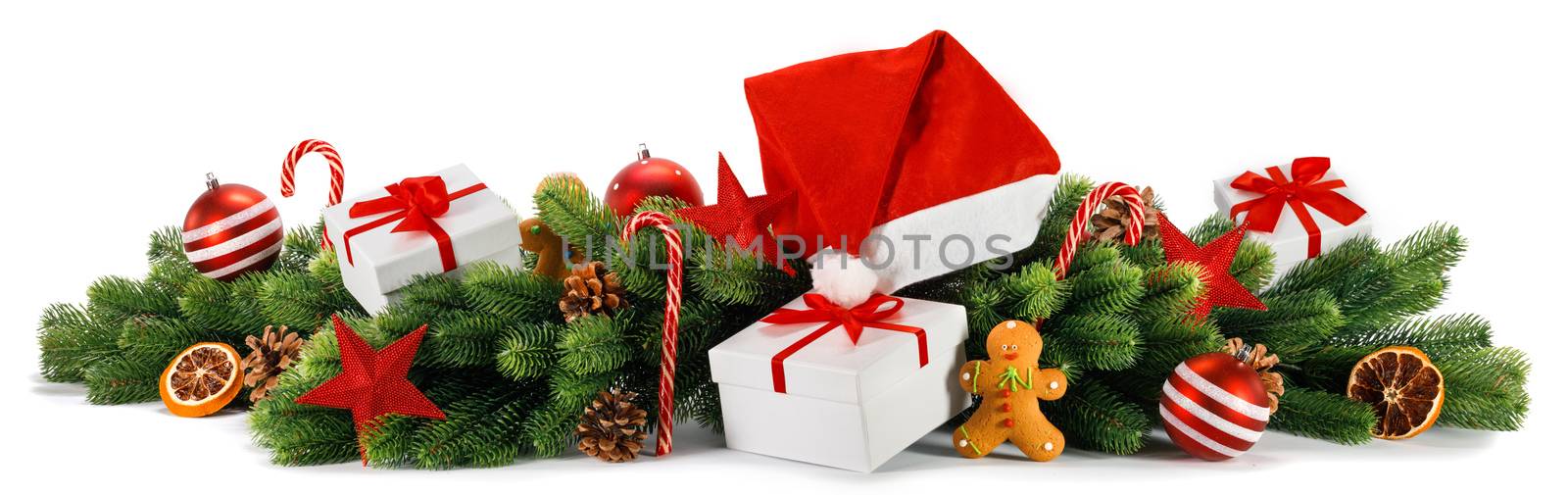 Merry Christmas greeting card idea with green fir tree, gifts, red Santa Claus hat, decor of balls and baubles, pine cones, candy canes and gingerbread cookies studio isolated on white background