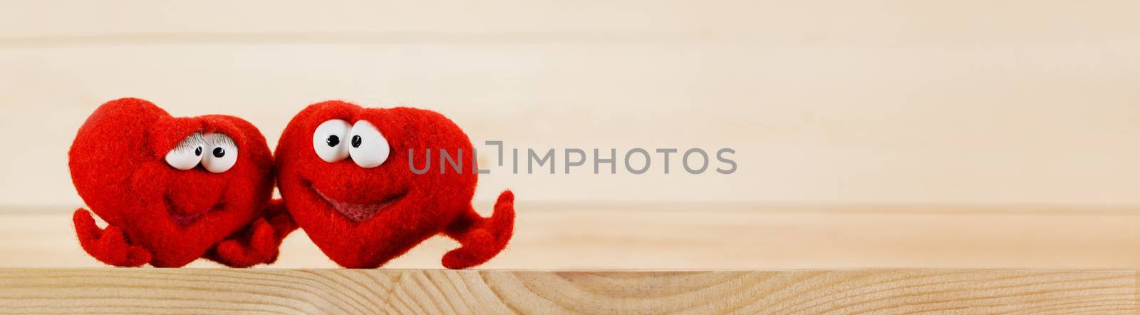 Two wool red hearts on wooden background with copy space for text, symbol of love, healtcare, valentines day concept