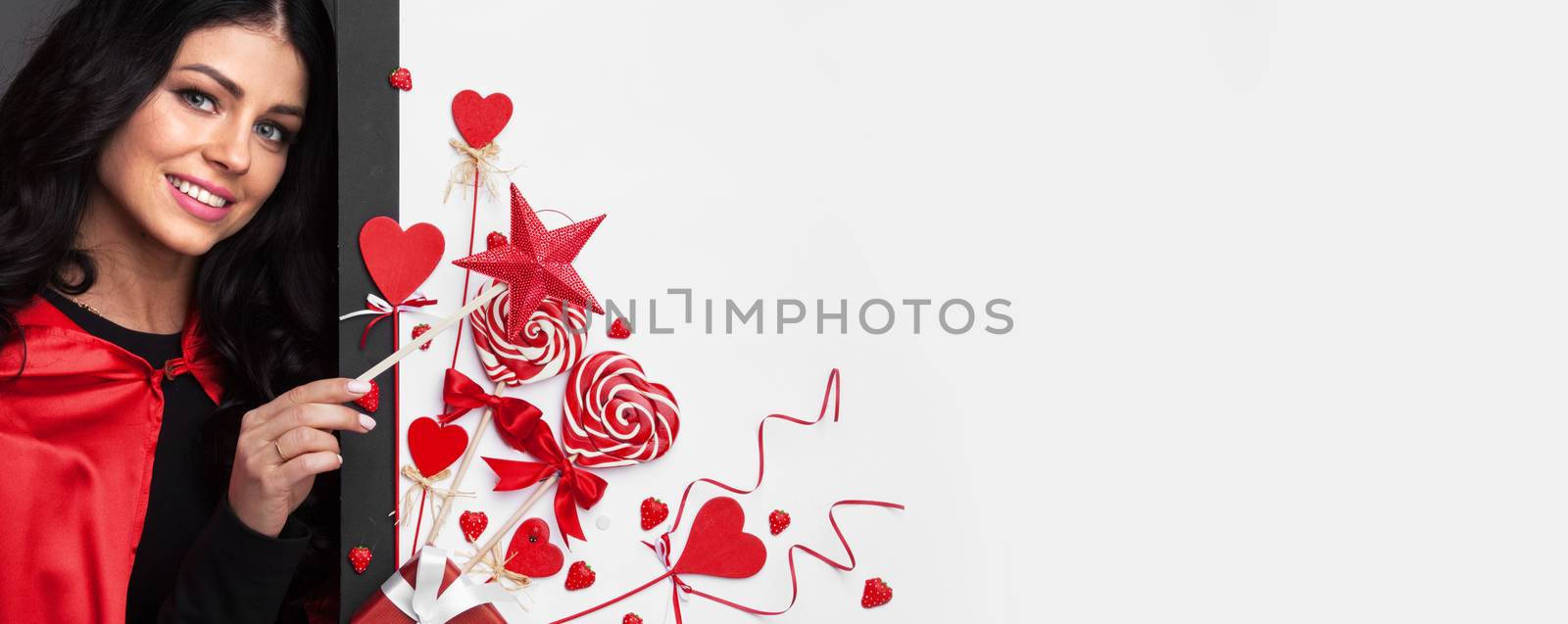 Gorgeous woman magician with star shaped magic wand making valentines day love heart decor isolated on white background
