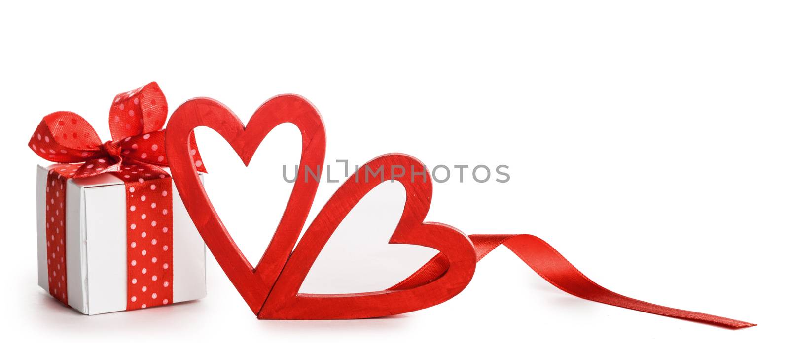 White box with red ribbon bow and two handmade wooden hearts isolated on white background Valentine day
