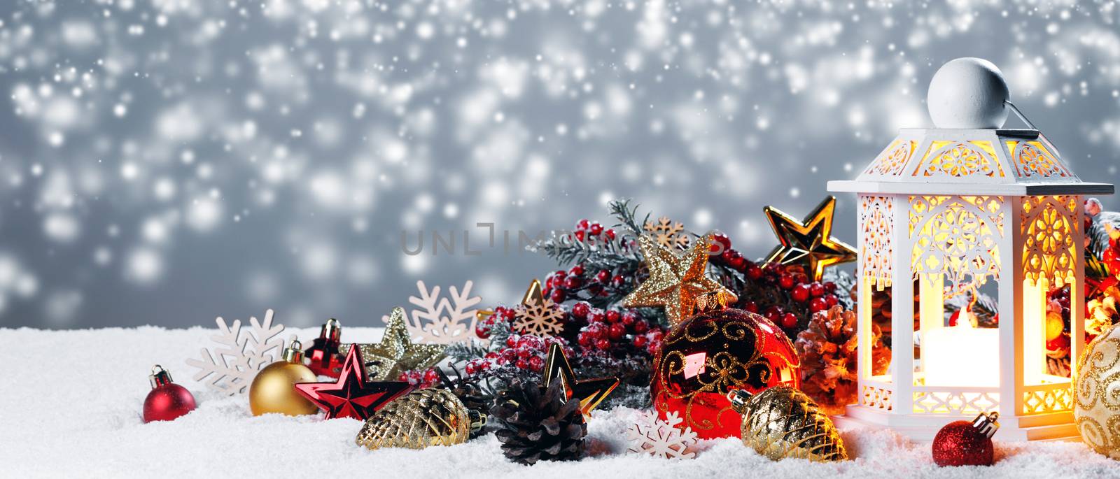 Christmas composition of colorful ornaments balls stars candles and fir tree branches on snow