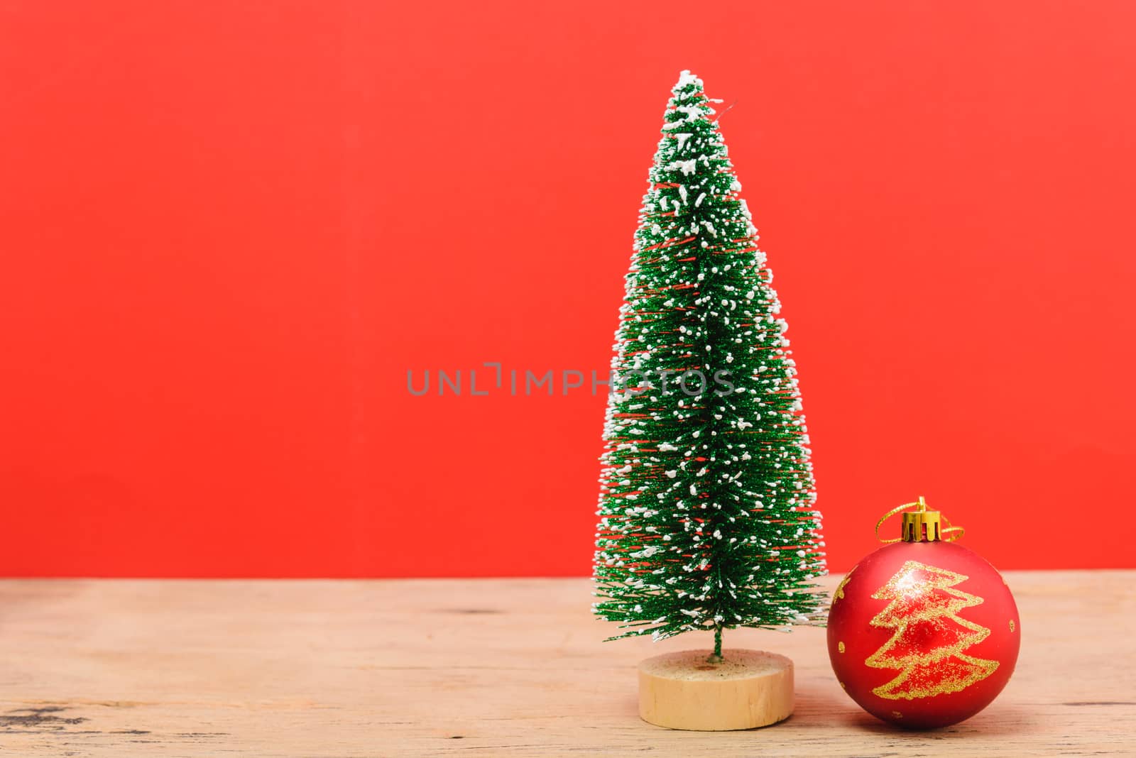 Christmas composition decorations, minimal green fir tree branches with snow and ball on red background. Merry Christmas concept. Copy space for text