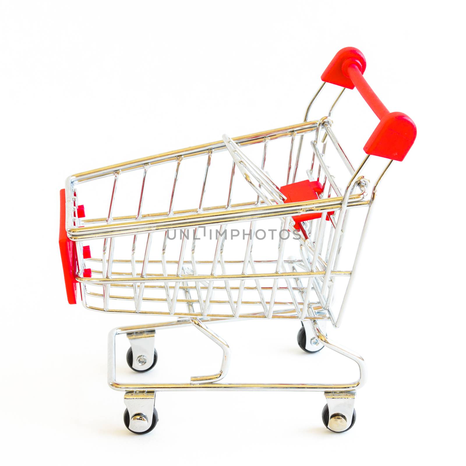 Small shopping cart isolated on white background. Tiny silver and red metallic empty push cart. Concept for online shopping and e-commerce.