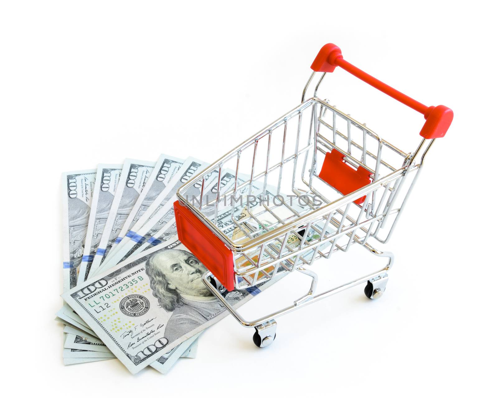 Stack of one hundred (100) dollars banknote and small shopping cart isolated on white background. Large denominations US bill with tiny silver, red metallic empty push cart, online shopping concept