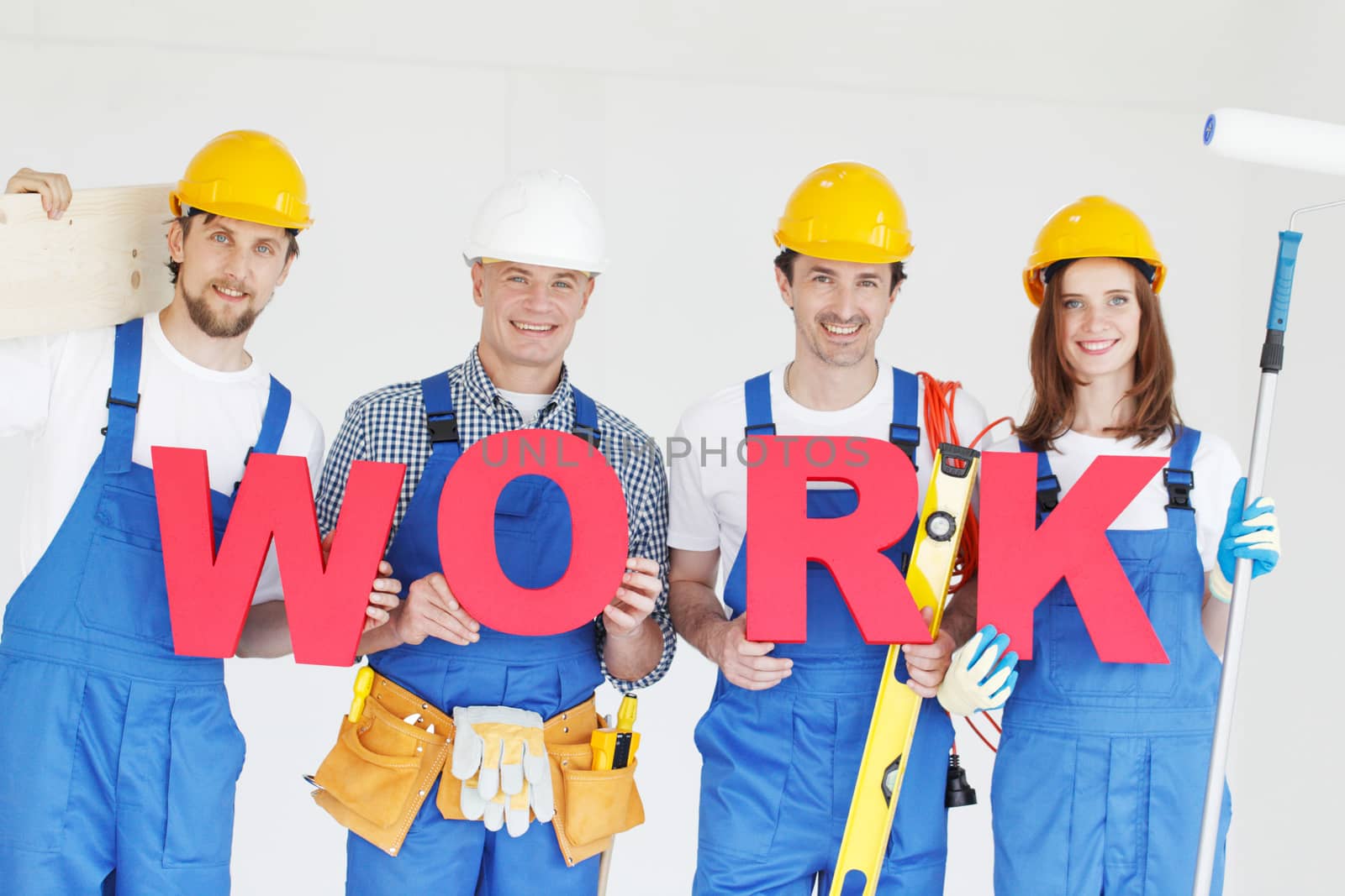 Portrait of happy smiling construction workers team with red work letters