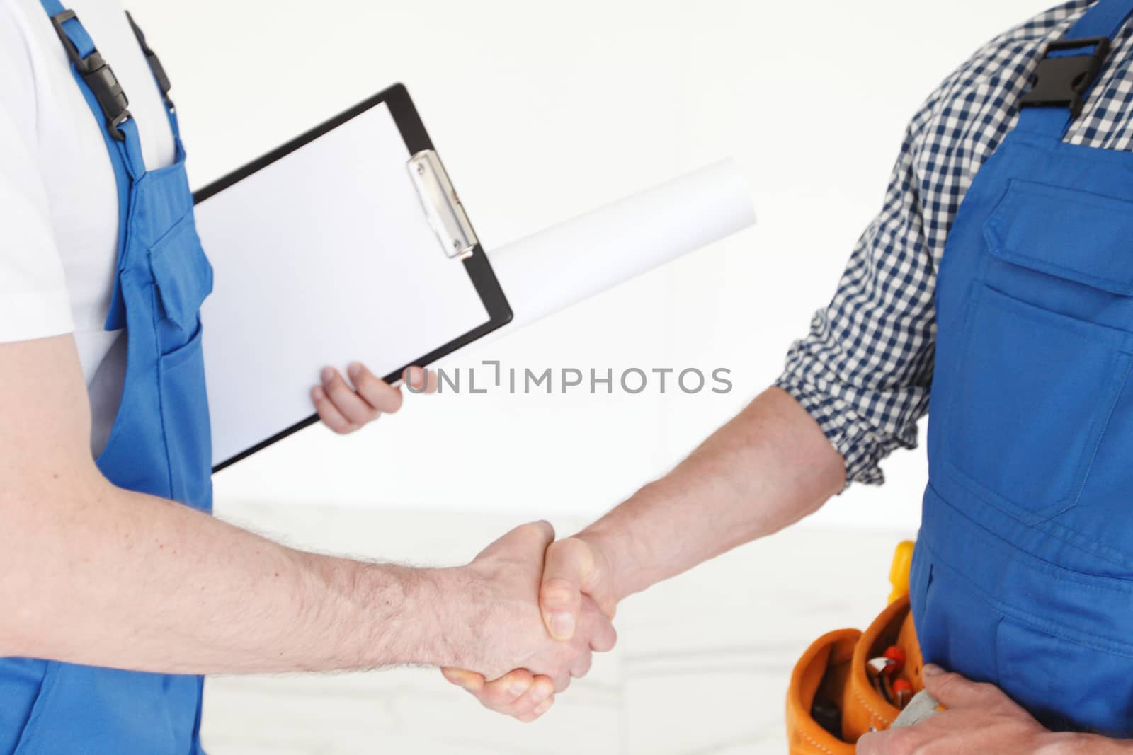 Two construction workers shaking hands, deal is finished , employment concept