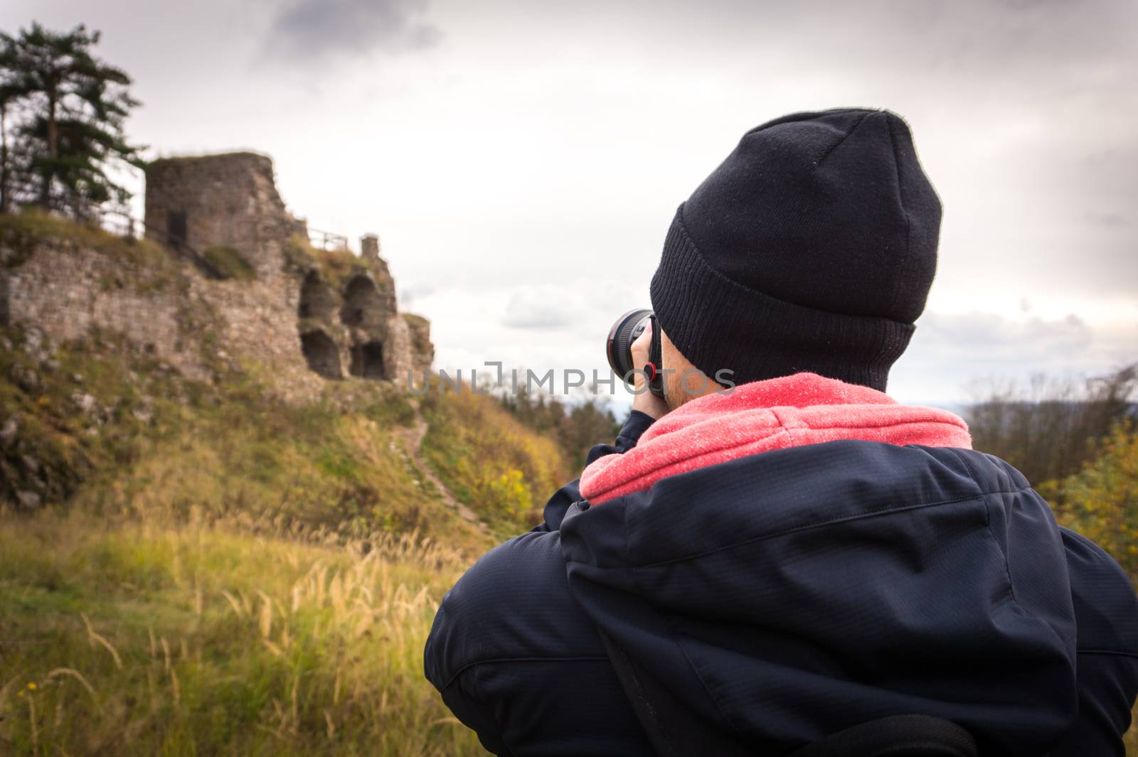 Young man tourist taking photos of castle ruin. Tourism. by petrsvoboda91