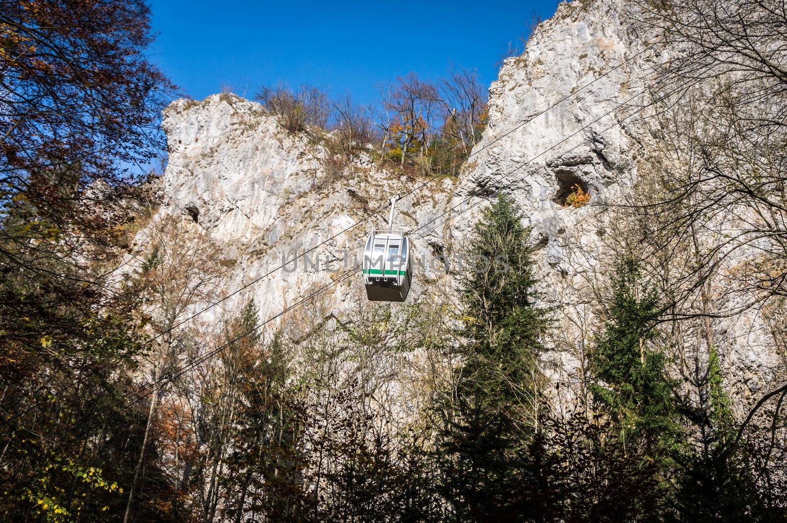 Cableway with blue sky and rocks background. Cable cabin in Moravia. Macocha Cable tramway. Translation of text in image: Macocha Cableway. by petrsvoboda91