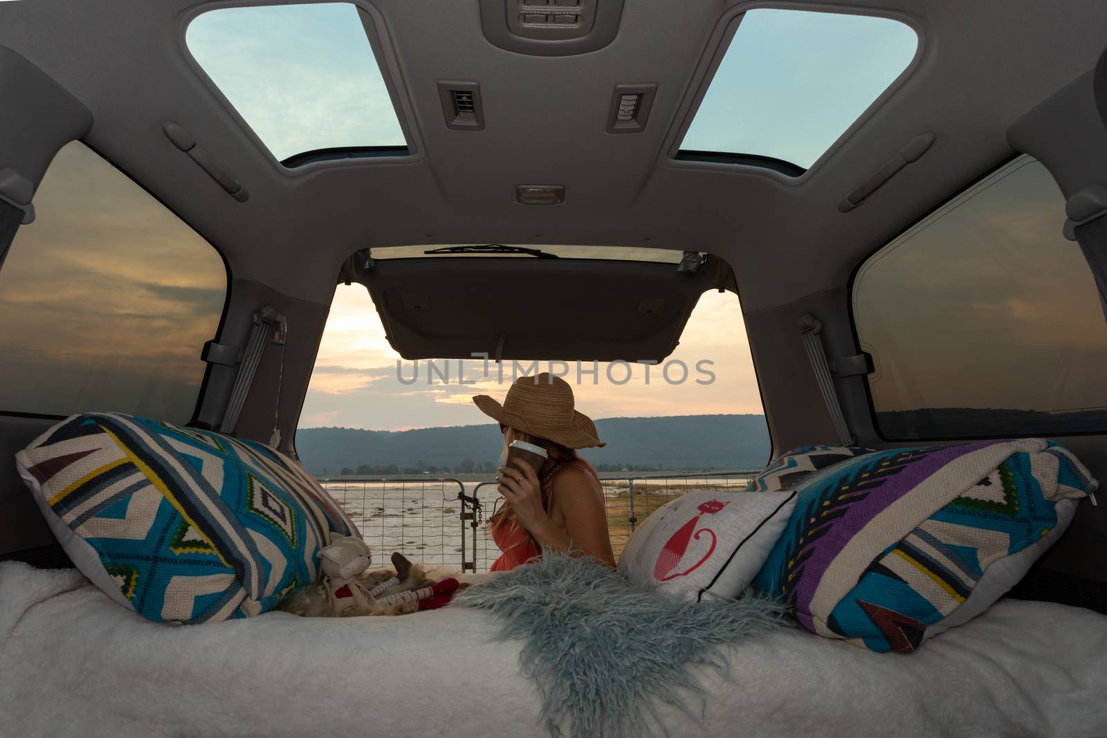 Woman on a road trip with her van takes a coffee break