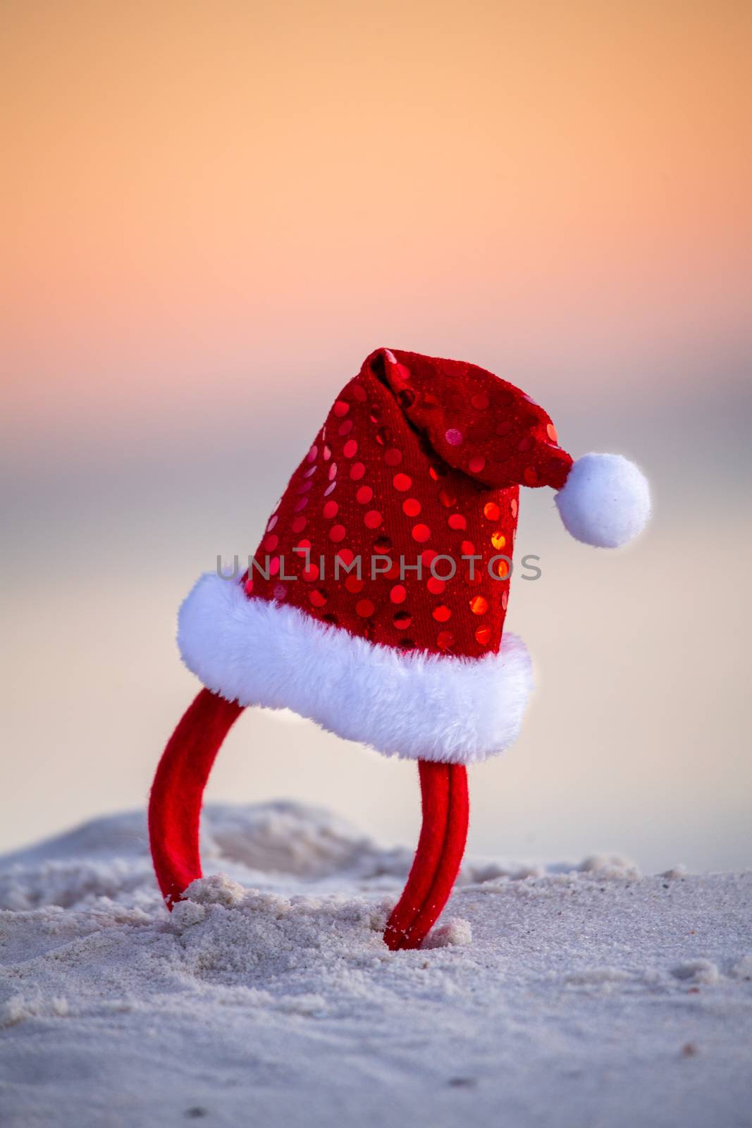 Sparkly red santa hat in the beach sand in Australia. Christmas by lovleah