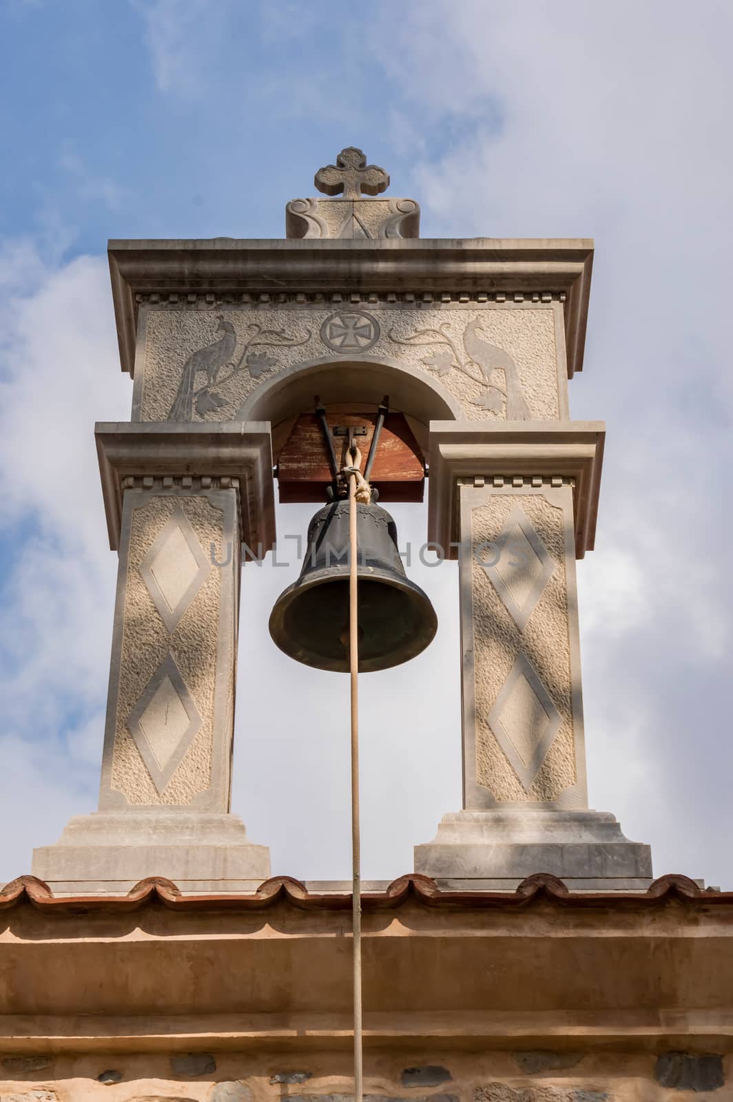 Bell hanging on a stone arch on an orthodox chapel in Crete