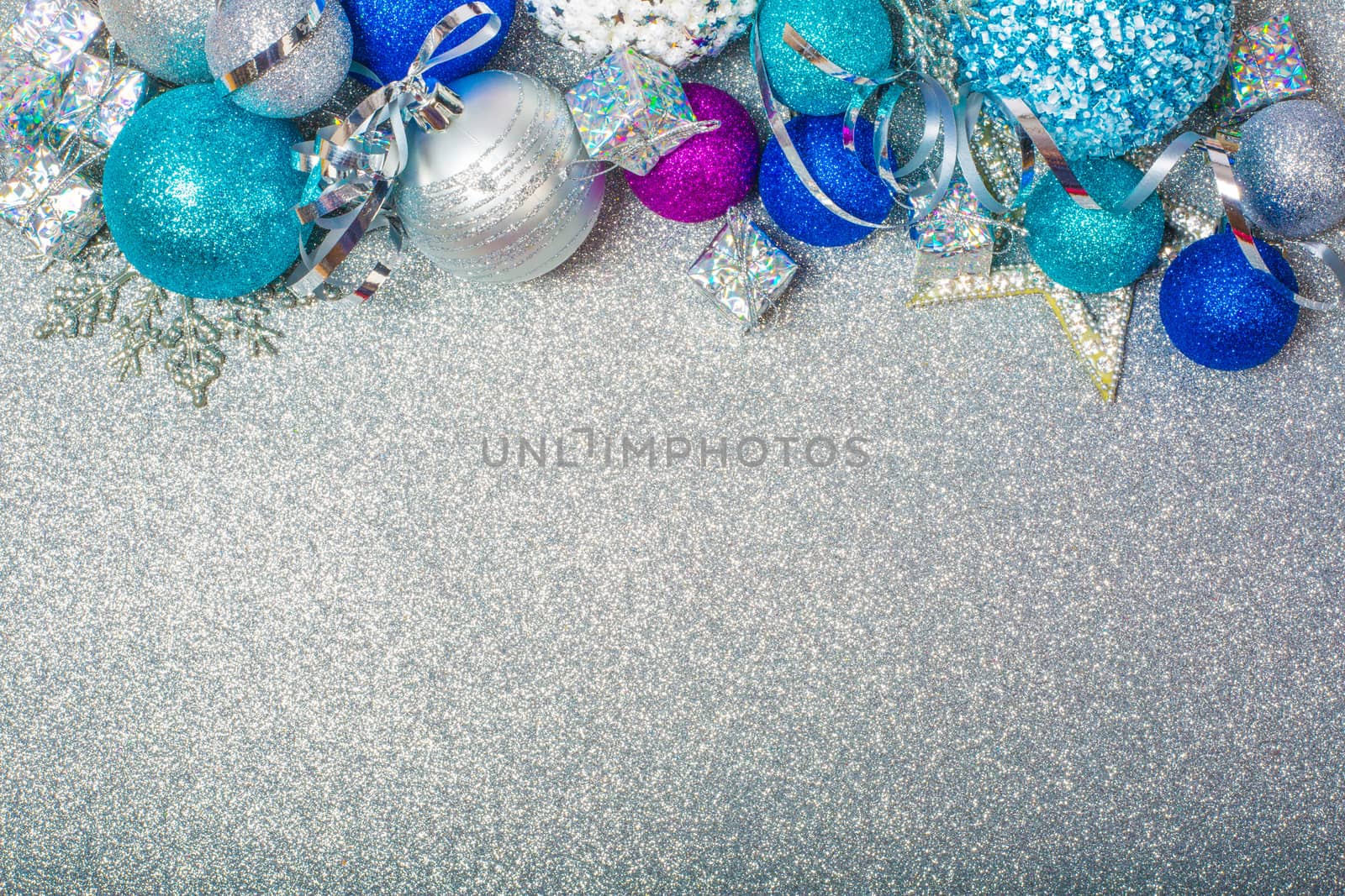 Christmas decoration of colorful glitter balls on silver glitter background with copy space for text new year card concept