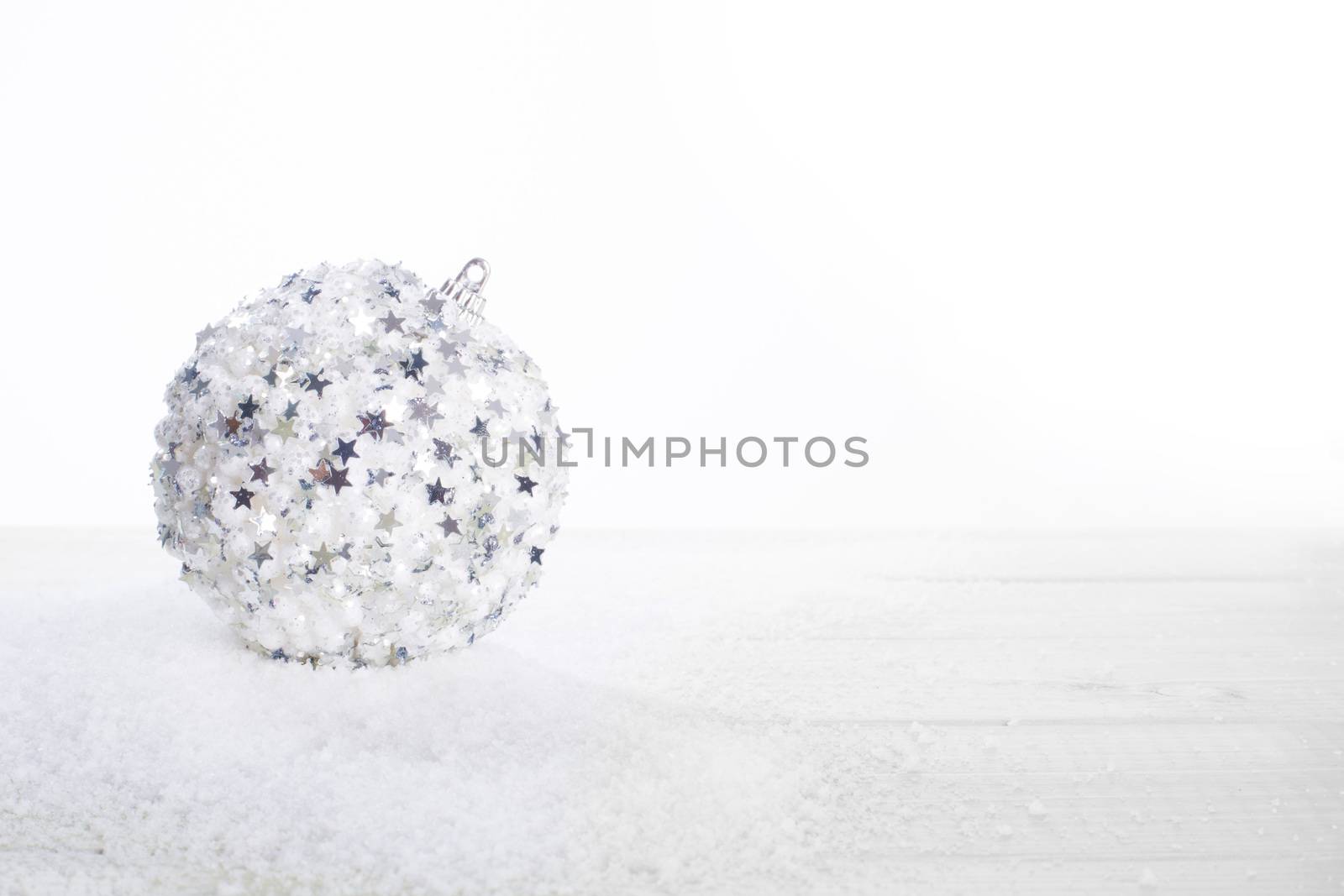 Christmas decoration of silver glitter ball on wooden background with copy space for text new year card concept isolated on white