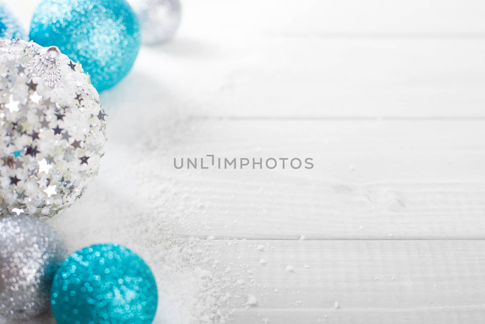 Christmas decoration of colorful glitter balls and snow on wooden background with copy space for text new year card concept