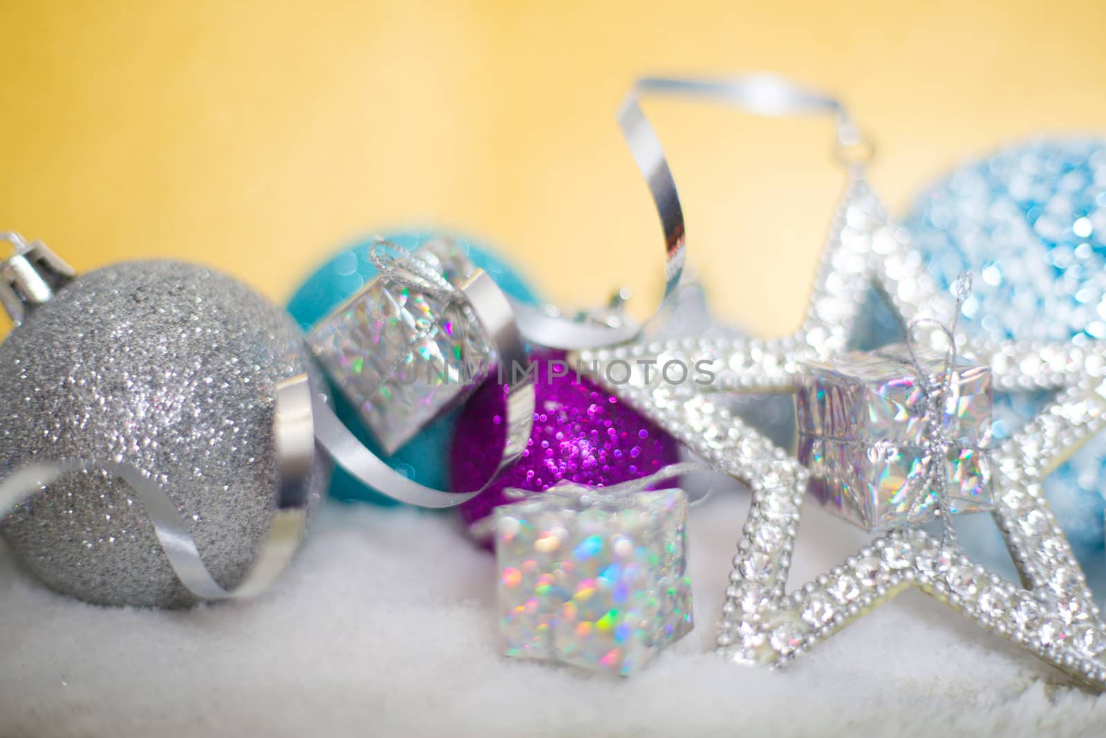 Blue and silver Christmas balls on snow on glitter background with copy space for text
