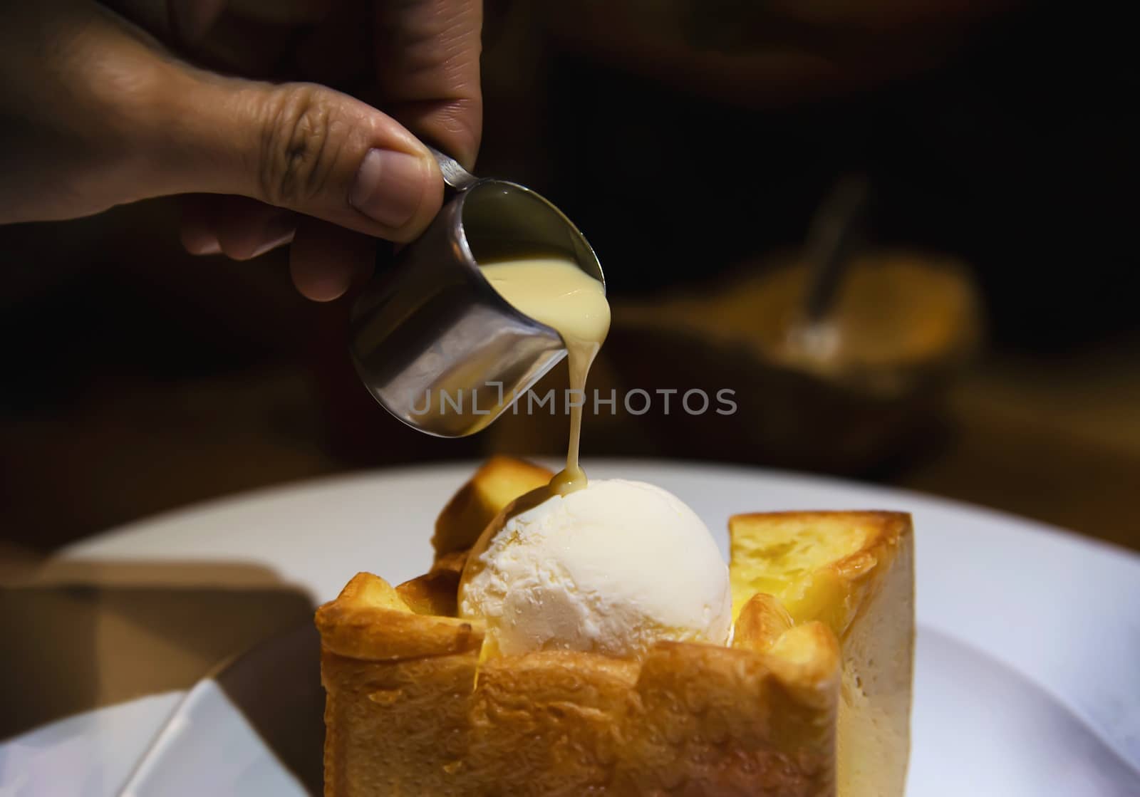 People pouring milk on ice cream bread toast - people with toast dessert sweet eating concept