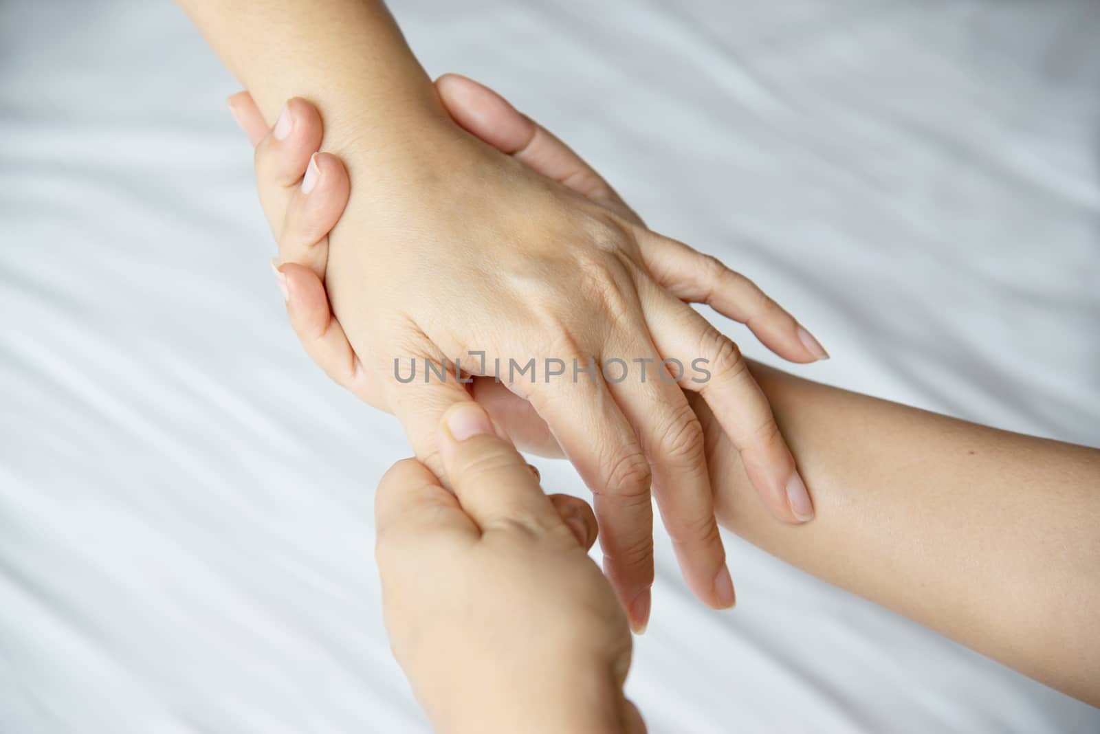 Hand spa massage over clean white bed background - people relax with hand massage service by pairhandmade