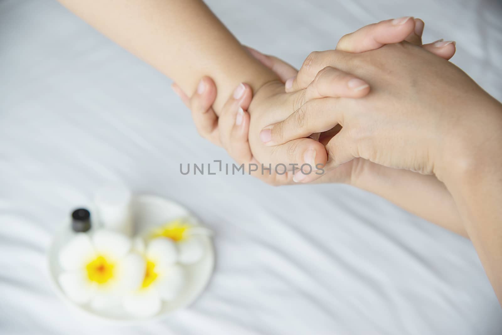 Hand spa massage over clean white bed background - people relax with hand massage service