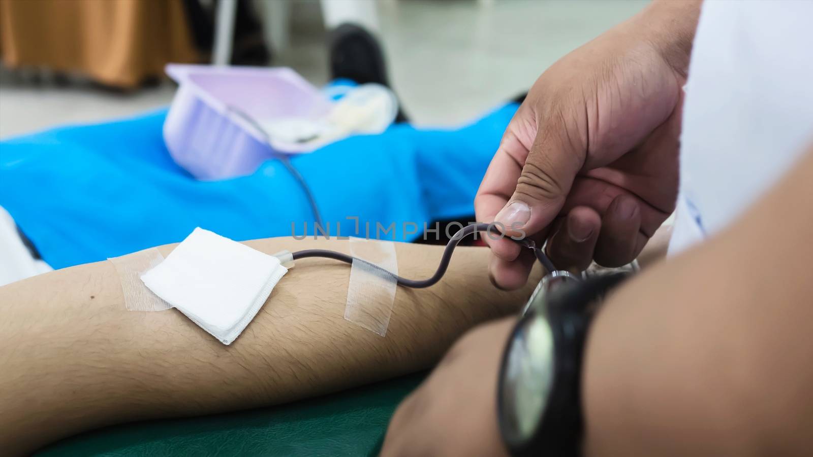 Volunteer man giving blood donation to cross red organisation - people with blood donation concept