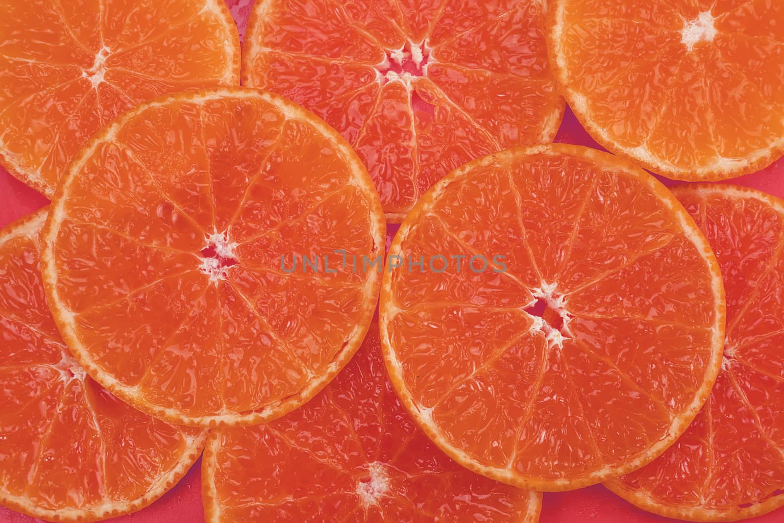 Fresh sliced juicy orange fruit set over orange background - tropical orange fruit texture for background use by pairhandmade