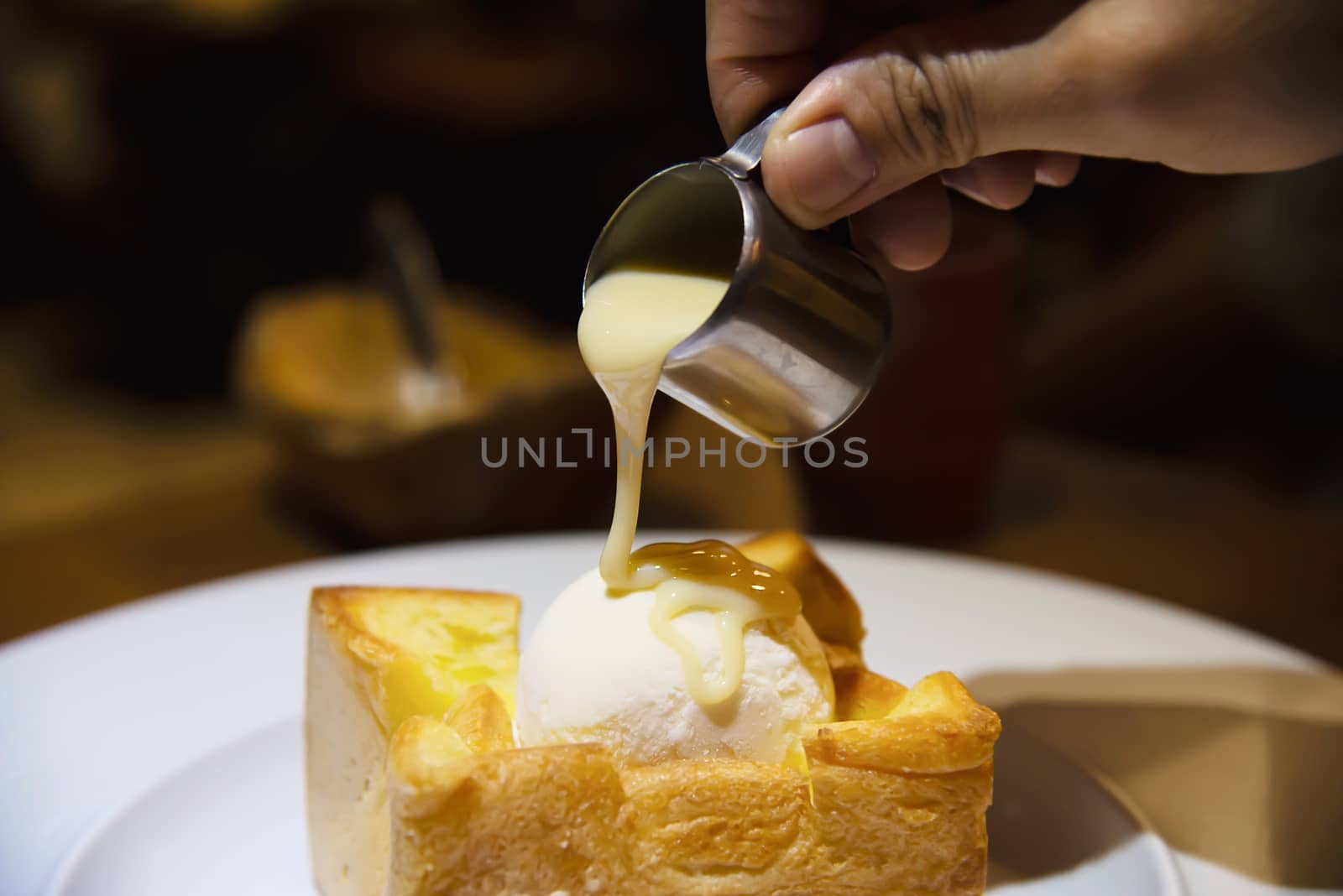 People pouring milk on ice cream bread toast - people with toast dessert sweet eating concept