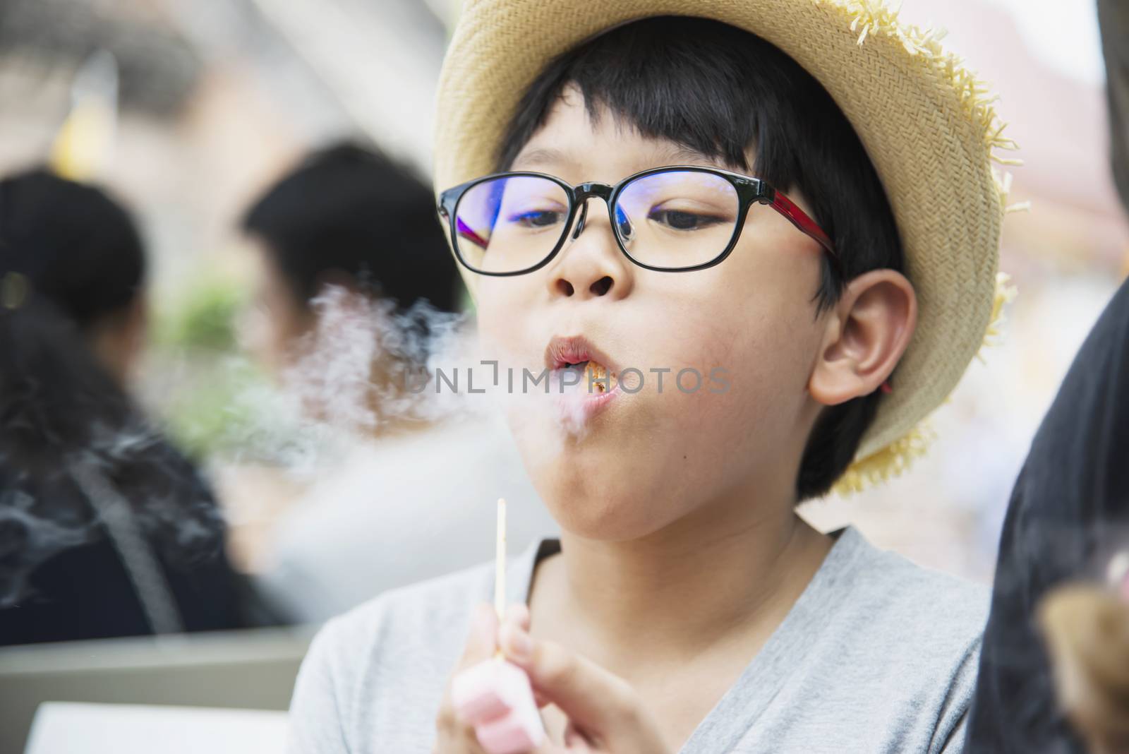 Asian boy eating smoking canny happily - people and snack happy time concept by pairhandmade