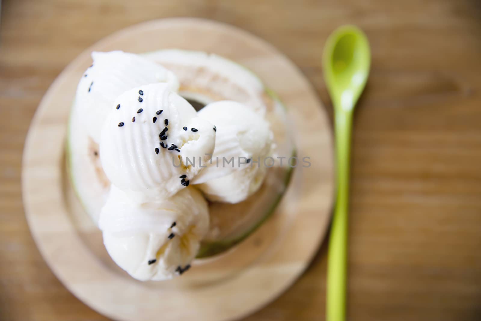Coconut ice cream serving in fresh coconut shell on wooden table - tasty famous sweet dessert by pairhandmade