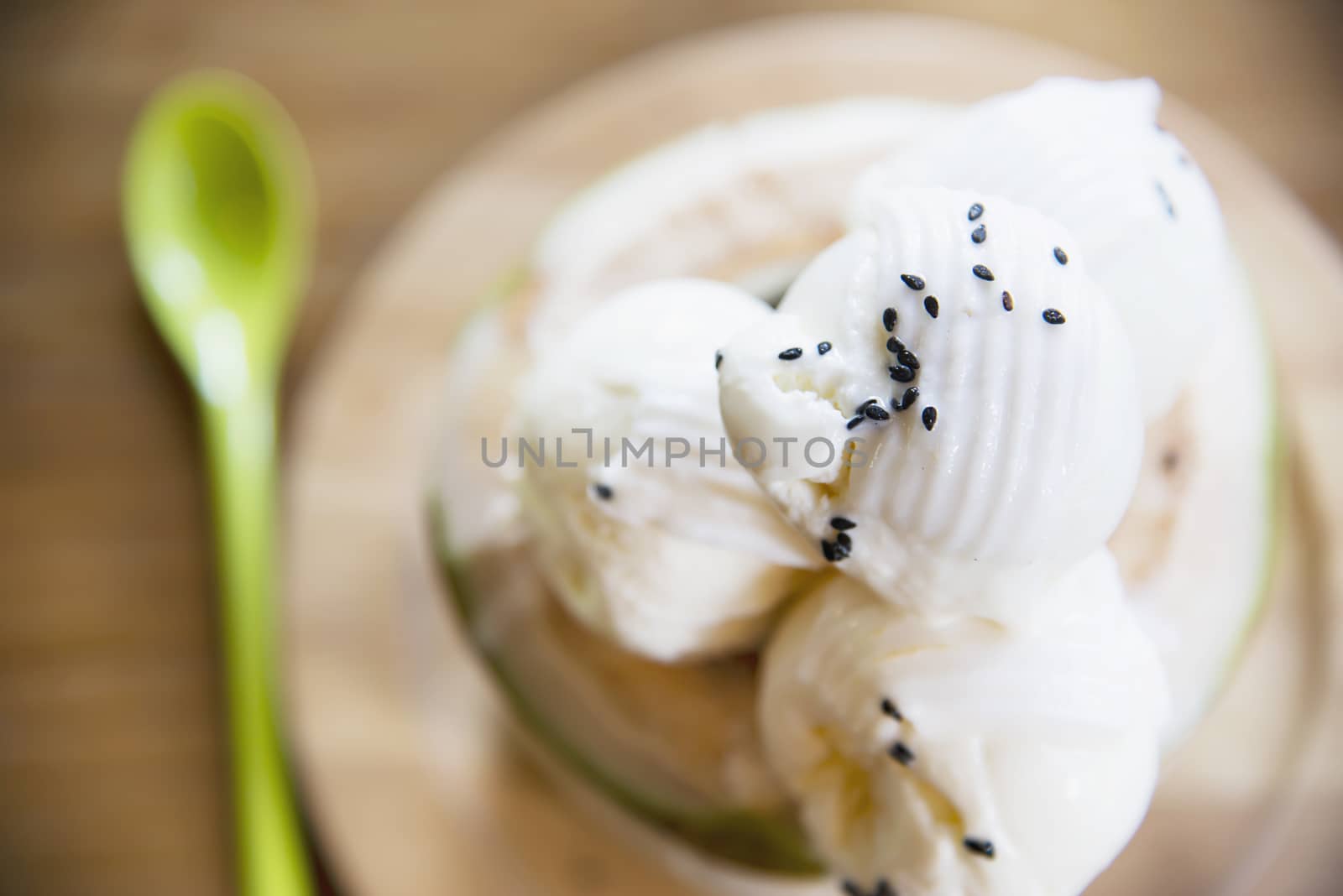 Coconut ice cream serving in fresh coconut shell on wooden table - tasty famous sweet dessert by pairhandmade