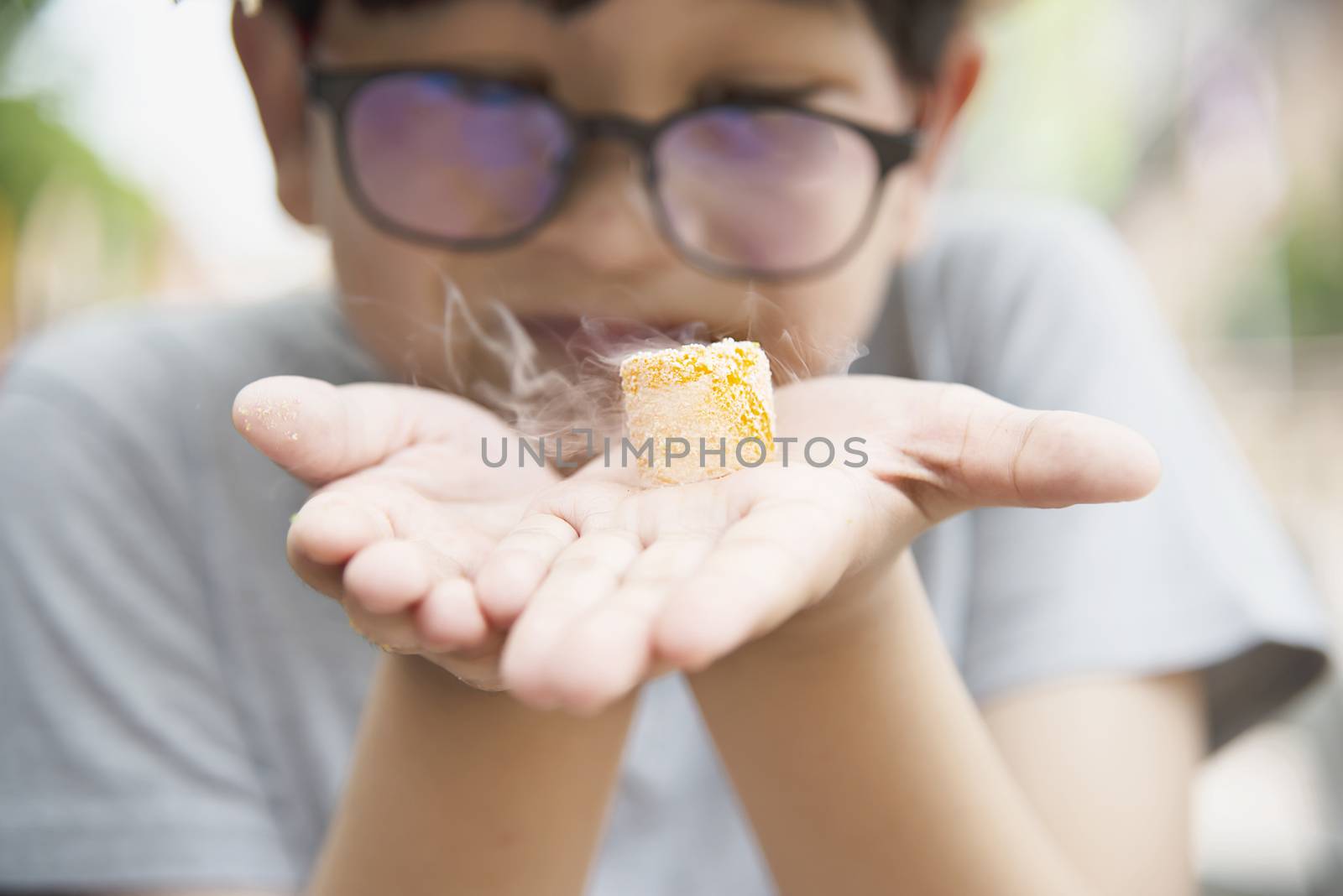 Asian boy eating smoking canny happily - people and snack happy time concept by pairhandmade