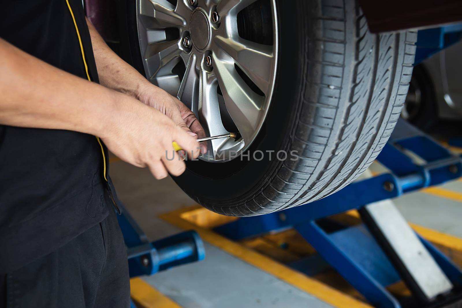 Technician is inflate car tire - car maintenance service transportation safety concept