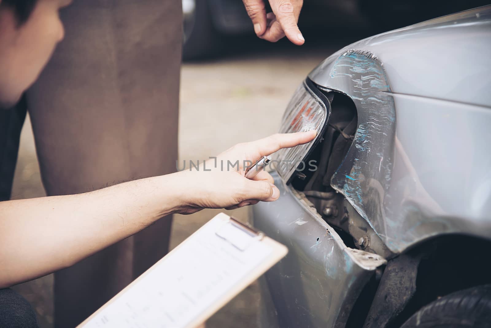 Insurance agent working during on site car accident claim process - people and car insurance claim concept