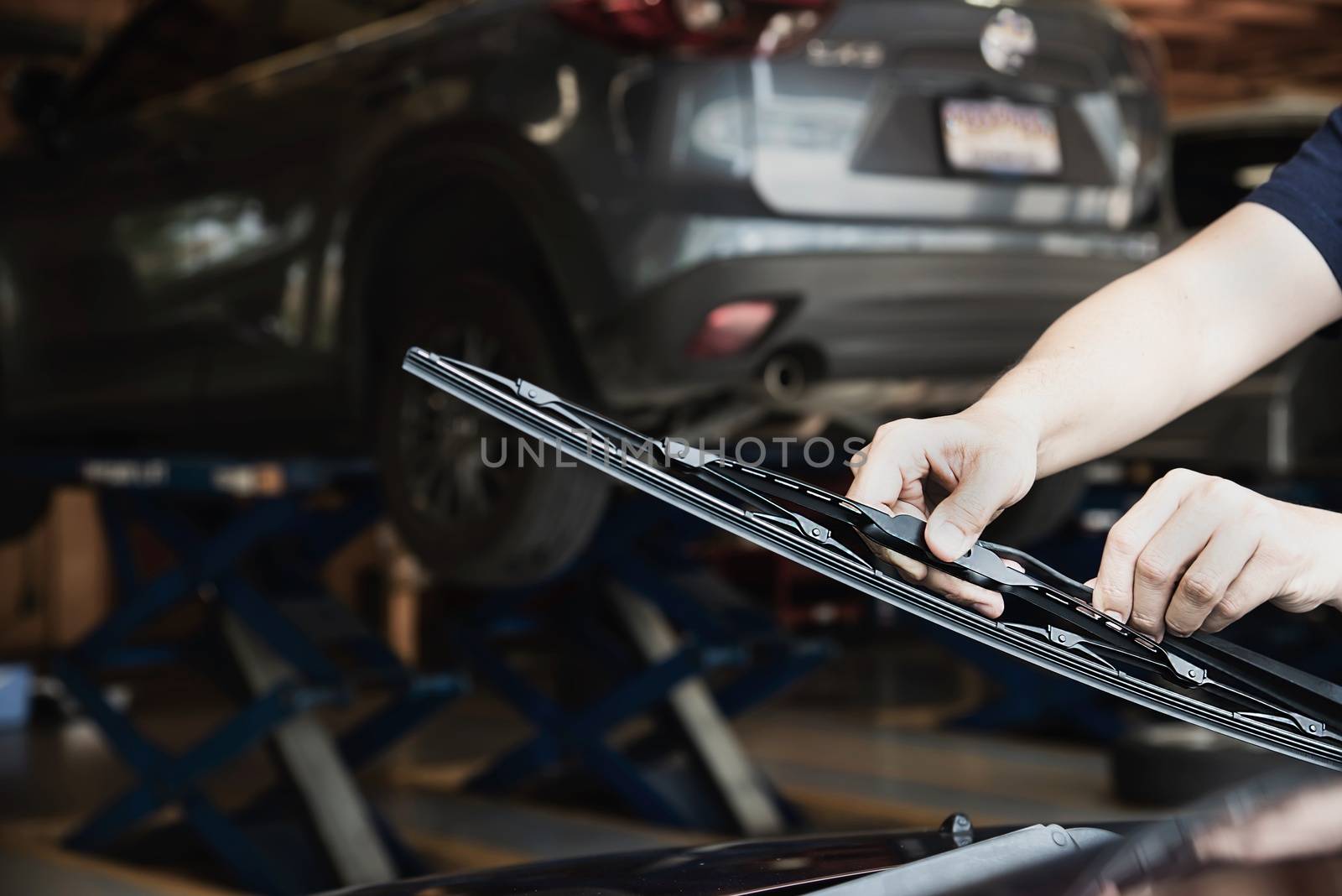 Man doing car wiper cleaning or changing maintenance - people with car maintenance concept