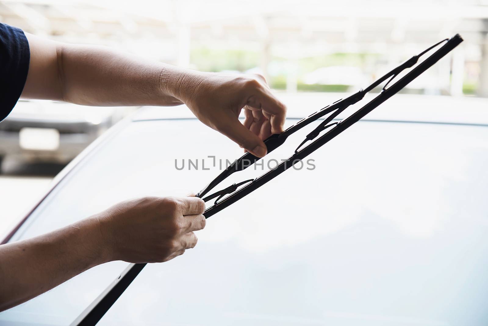 Man doing car wiper cleaning or changing maintenance - people with car maintenance concept