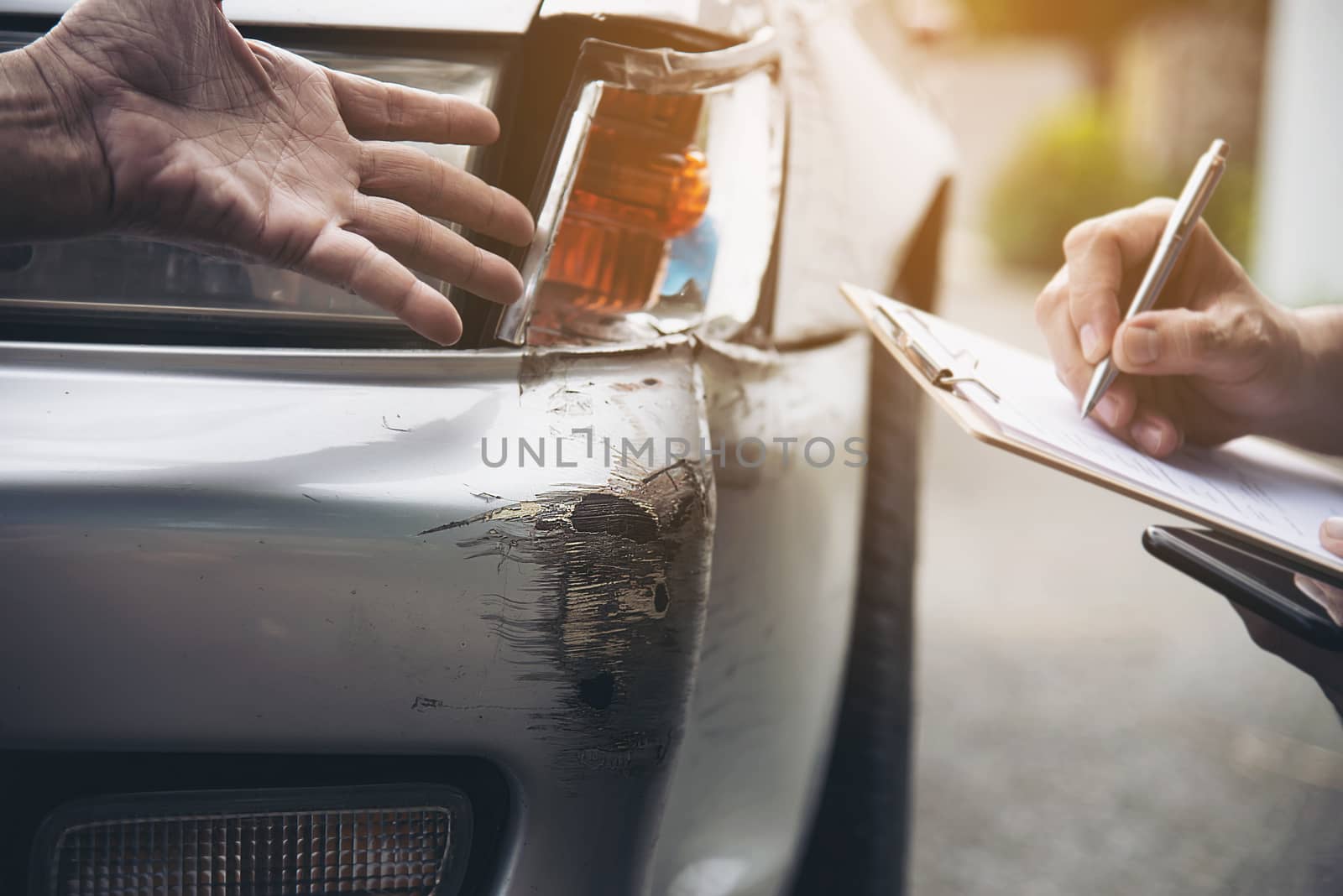 Insurance agent working during on site car accident claim process - people and car insurance claim concept