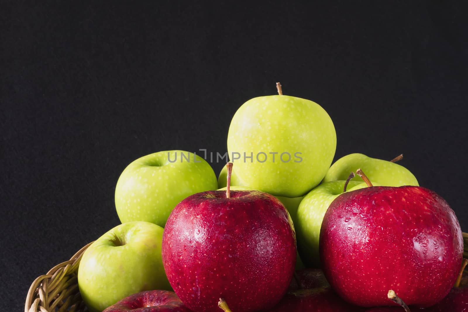 Fresh colorful apple with water drop on skin over gray background - clean fresh fruit background concept