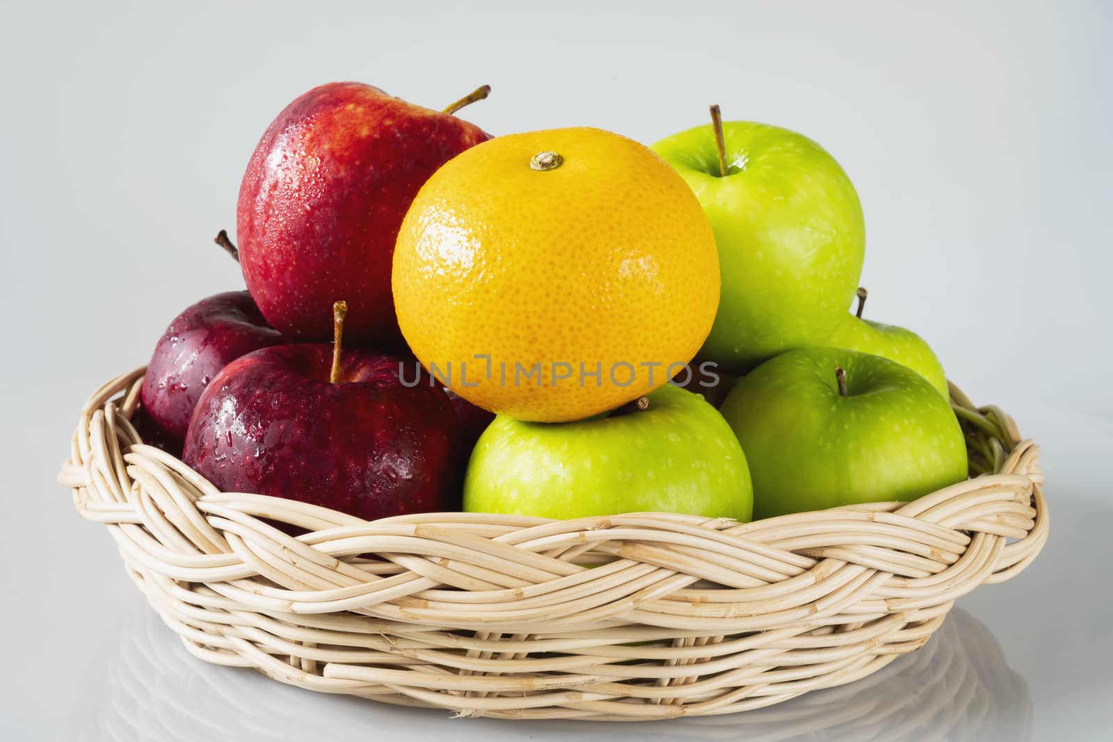 Fresh red green apple and orange over gray black background - fresh fruit background concept by pairhandmade