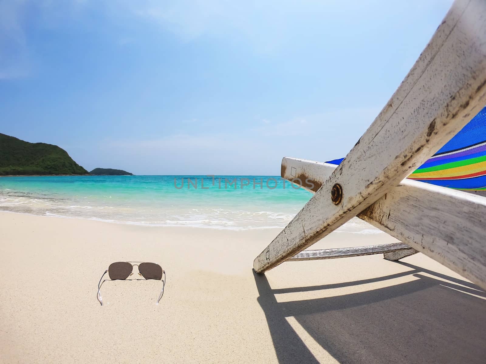 Relax beach chair with fresh coconut on clean sand beach with blue sea and clear sky - sea nature background relax concept