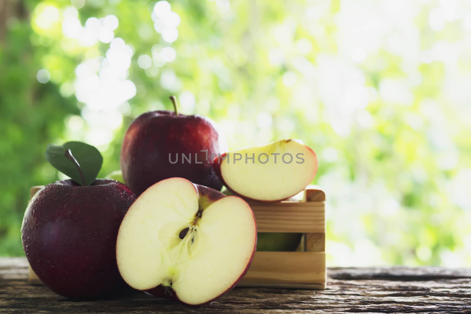 Fresh apple in wooden box over green nature background - fresh fruit background concept
