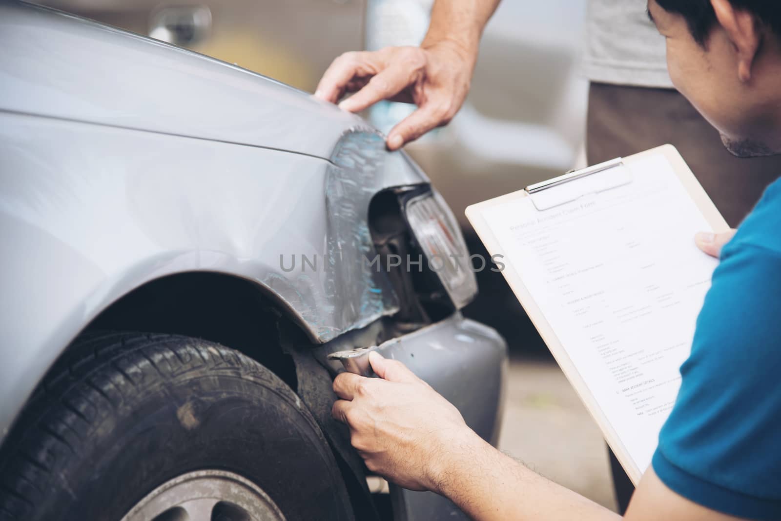 Insurance agent working during on site car accident claim process - people and car insurance claim concept