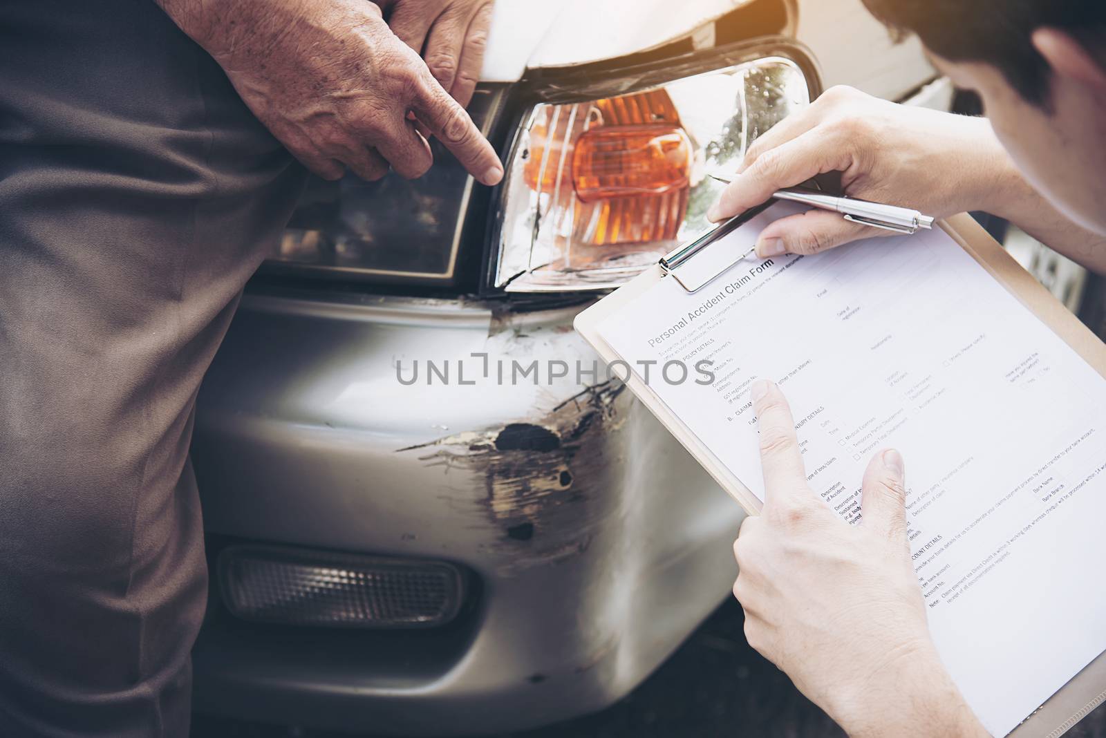 Insurance agent working during on site car accident claim process - people and car insurance claim concept by pairhandmade