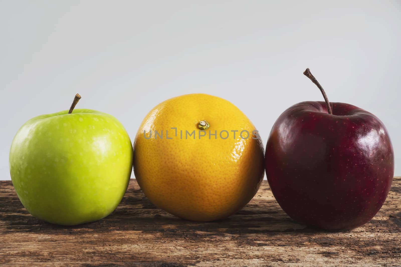 Fresh red green apple and orange over gray black background - fresh fruit background concept