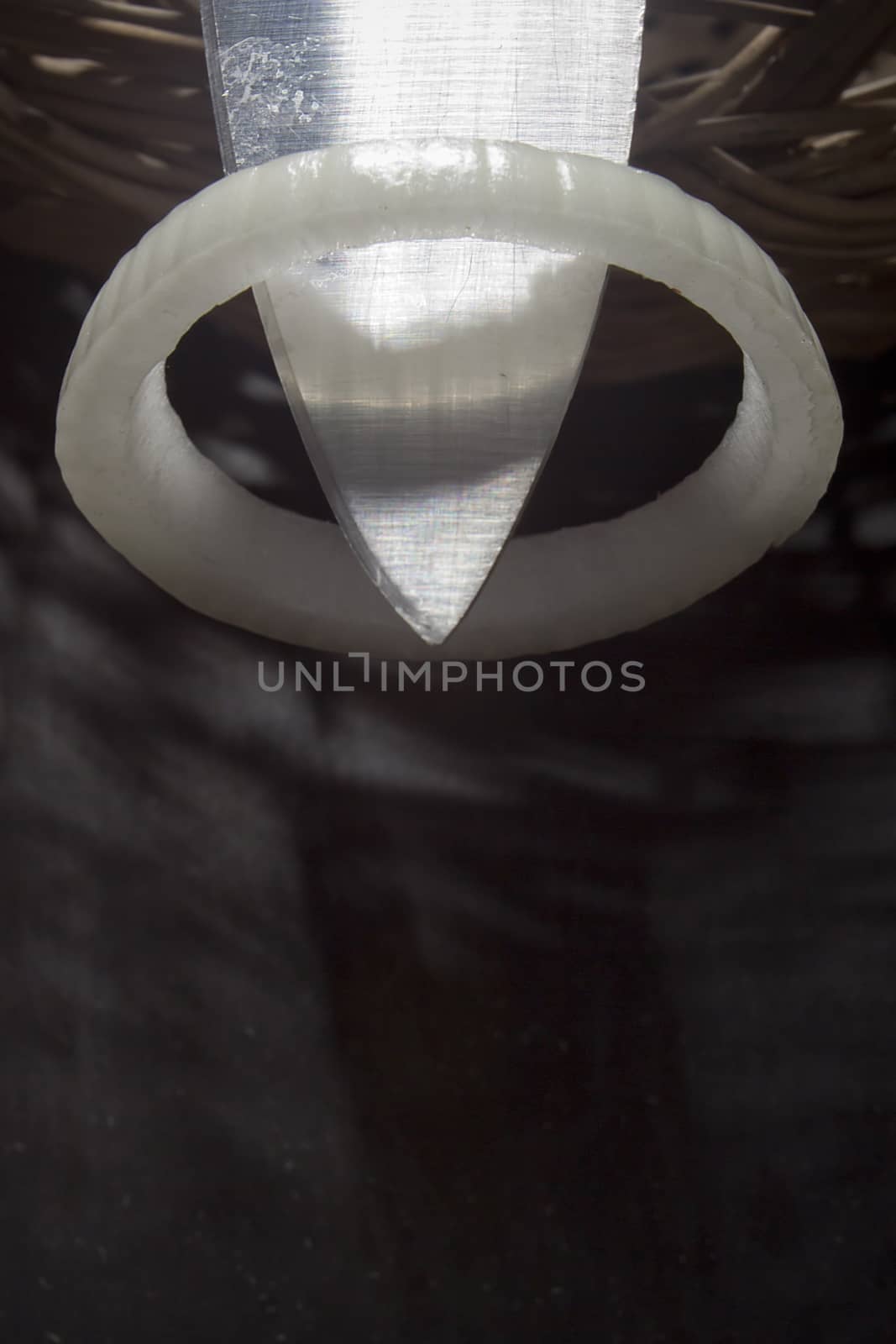 Onion rings and knife on a black background