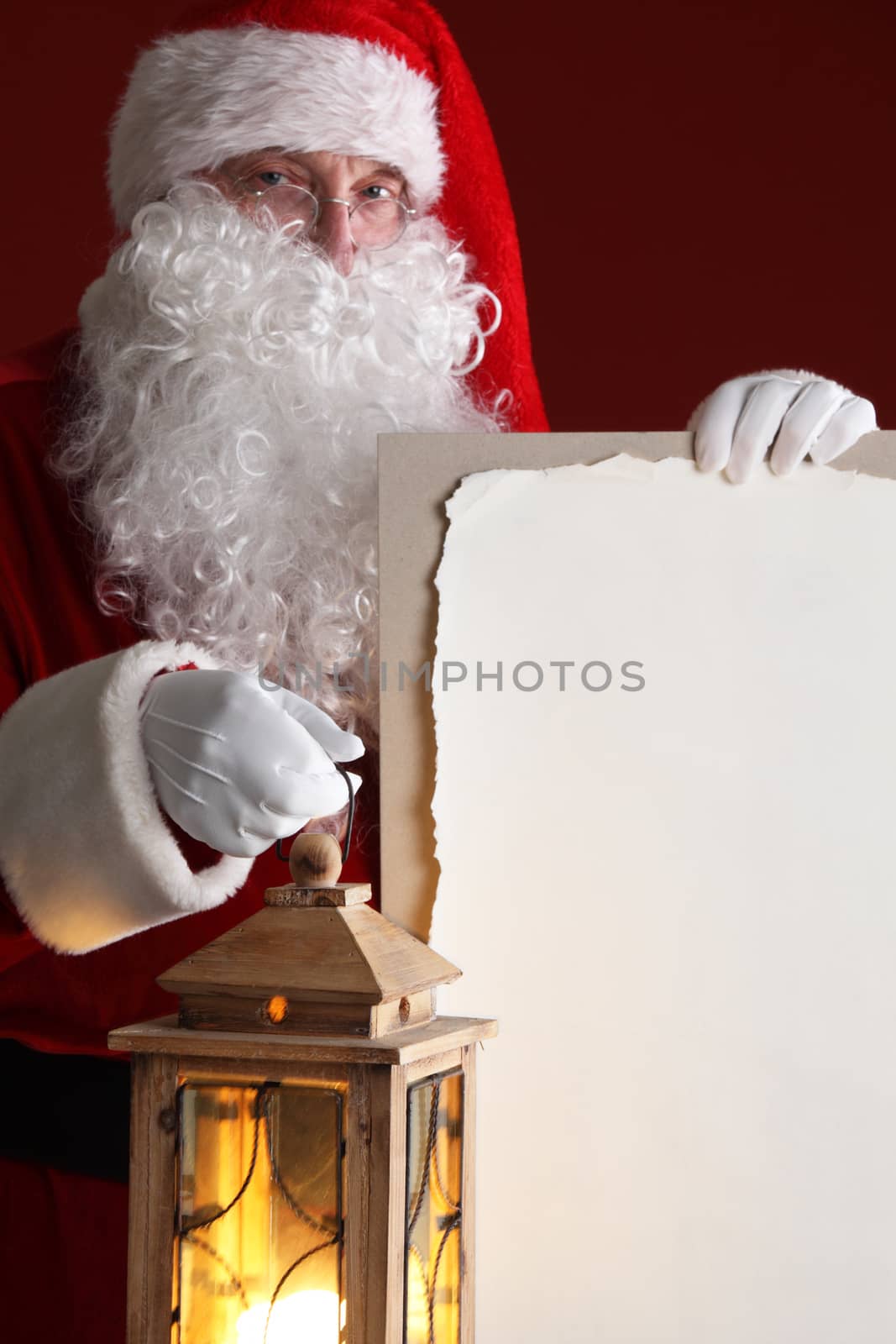 Santa Claus with lantern holding vintage paper billboard with copy space for text