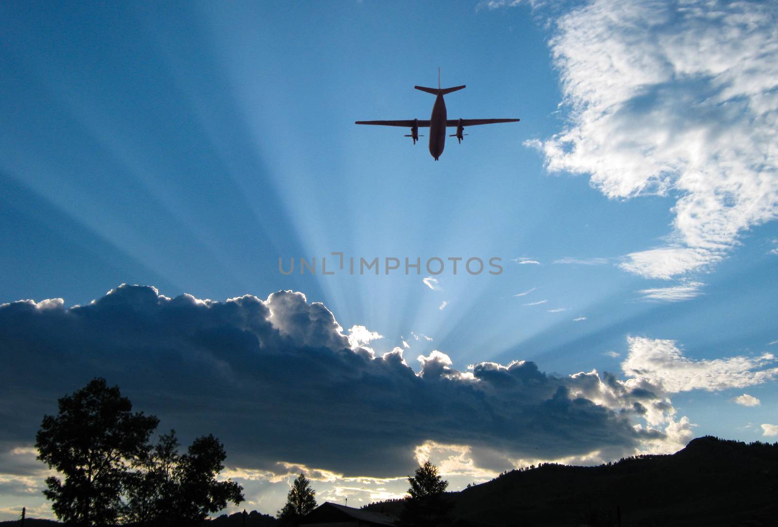 Passenger plane in the sky flying to meet the sunset. The sun shines through the clouds.